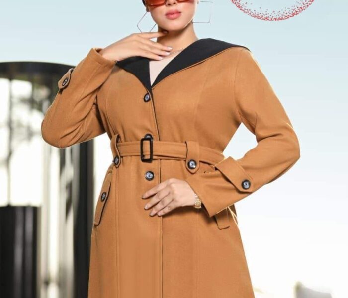 Elegant imported wool coat in camel color with black collar details, featuring a belt and button accents, worn by a stylish woman with sunglasses and a headscarf.